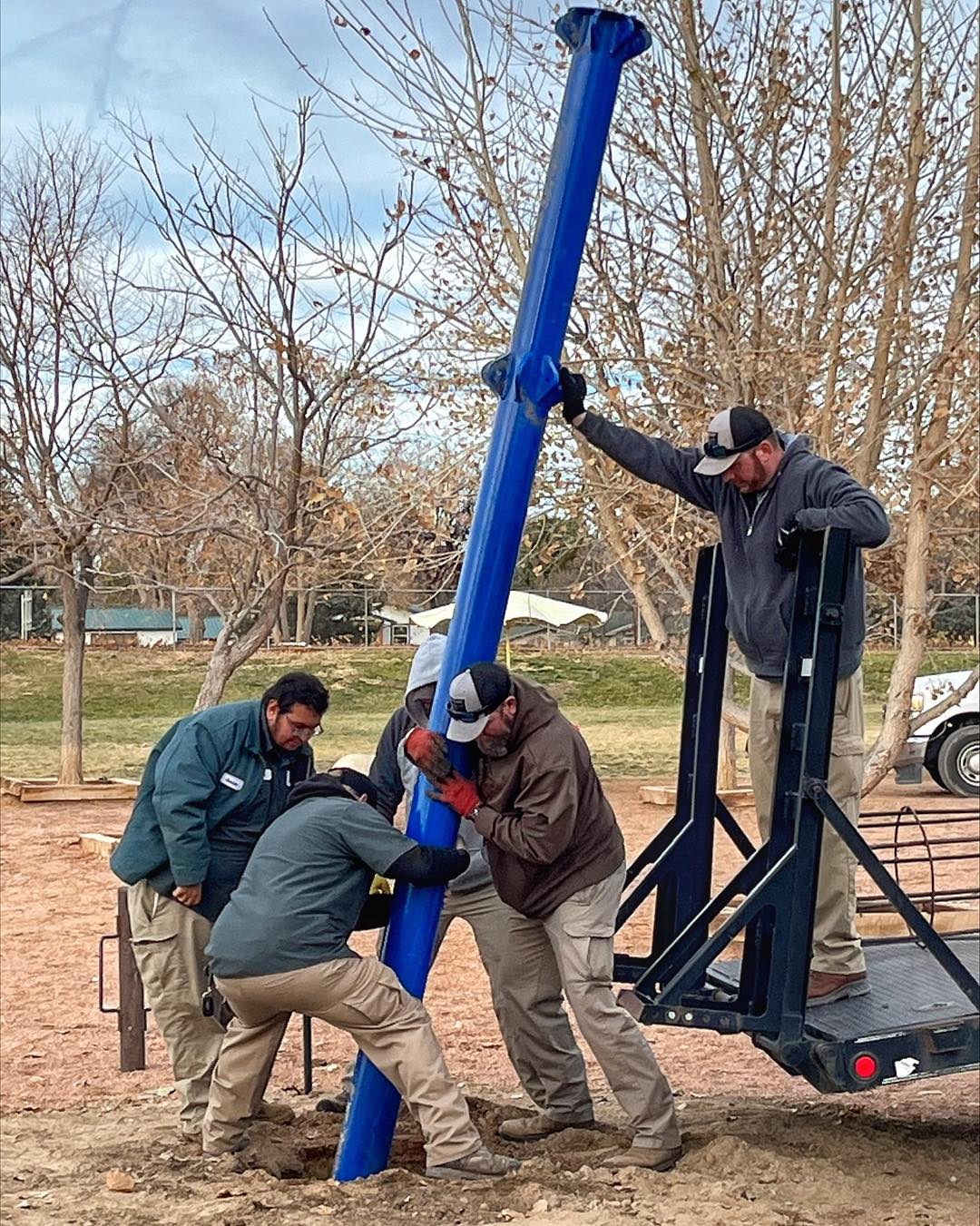 Image 14 of 14 in gallery section. Image title is Parks and Rec employees working on playground equipment.