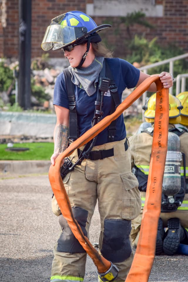 Image 1 of 14 in gallery section. Image title is Firefighter with hose.